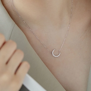Gros plan du collier croissant de lune en argent S925 serti de pierres de zircone cubique