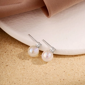 Detailed view of silver moonstone earrings with zircon inlay on stone display stand