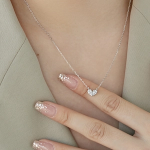 Collier cœur en argent S925 avec pendentif en zircon porté sur un blazer décontracté