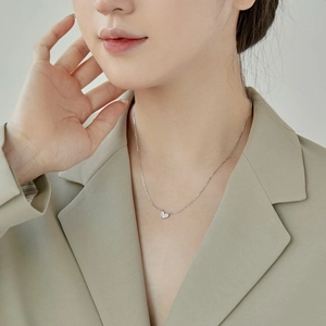 Gros plan d'un collier cœur en argent S925 avec micro zircons sur un mannequin femme