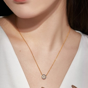 Collier élégant œil porte-bonheur doré serti de cristaux bleus sur le cou d'une femme