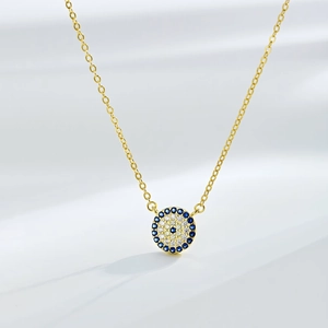 Vue rapprochée du pendentif œil maléfique doré serti de zircons bleus et blancs brillants