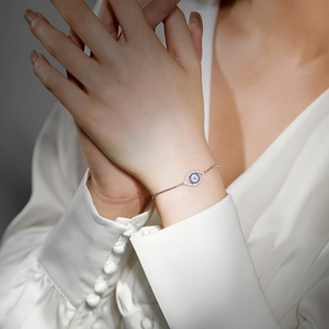Détail du bracelet œil protecteur en argent S925 avec zircons bleus sur poignet féminin