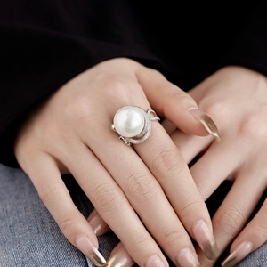 Macro shot of S925 silver ring featuring a large white pearl and zircon pave butterfly detail