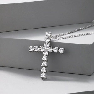 Vue détaillée d'un pendentif croix en argent sterling serti de onze zircons en cœur