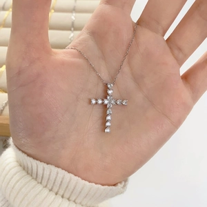Gros plan du pendentif croix en argent 925 serti de zircons en forme de cœur à la main