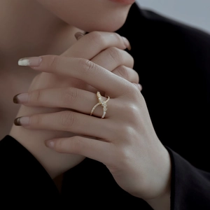 Elegante anello a X in argento S925 dorato con zirconi sulla mano della modella