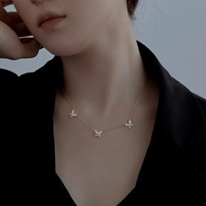 Détail de collier papillon doré serti de zircons brillants sur chaîne délicate