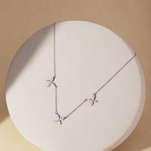 Détail de collier papillon en argent avec des zircons blancs scintillants