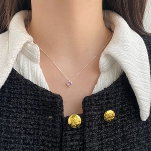 Close-up of S925 sterling silver heart necklace with pink zircon worn on a model's neck