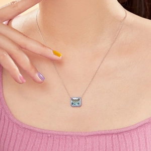 Close-up of S925 silver necklace featuring a blue gemstone pendant with purple enamel