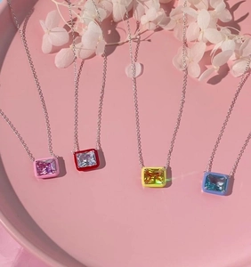 Detailed view of four colorful enamel candy pendants on silver-tone necklaces