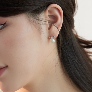 Close-up of S925 sterling silver crown earrings with natural freshwater pearls on a model