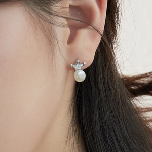 Close-up of S925 sterling silver crown pearl earrings worn on a female model