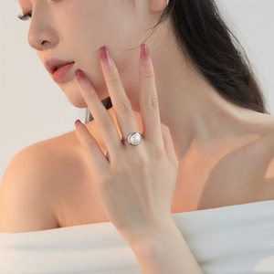 Macro detail of a natural freshwater pearl set in a polished silver open ring band