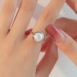 Close-up of elegant S925 silver ring with a large white freshwater pearl on finger