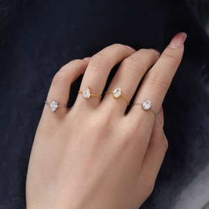 Detailed view of elegant chain rings with pear and oval cubic zirconia on hand