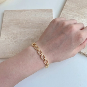 Detail eines vergoldeten Schweinenasen-Gliederarmbands mit Zirkonia-Pflasterung