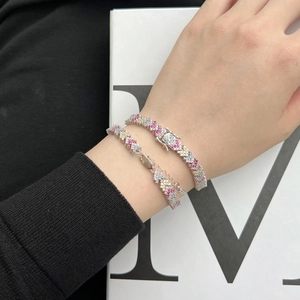 Detail of layered S925 silver tennis bracelets with colorful V-shaped zircon settings