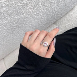 Détail d'une bague en argent S925 avec zircon rose en forme de cœur portée au doigt