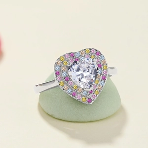 Gros plan sur une bague en argent S925 avec halo de zircons colorés et cœur en cristal