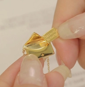 Golden envelope pendant necklace with movable insert showing laser engraved thank you note