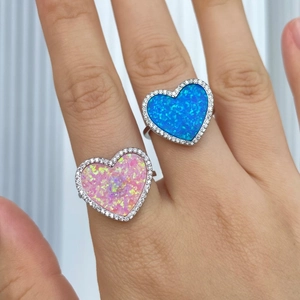 Close-up of S925 silver heart rings featuring pink and blue opal stones with side diamonds