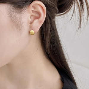 Close-up of minimalist round matte gold stud earring made of S925 sterling silver