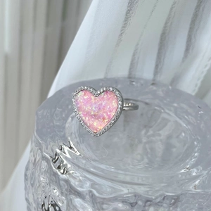 Detailed close-up of heart-shaped pink opal ring with halo diamonds on S925 silver band