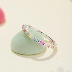Close-up of rainbow baguette-cut colorful zircons on a silver S925 sterling silver ring