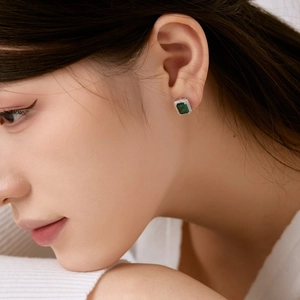 Gros plan d'une boucle d'oreille élégante avec émeraude verte et contour en zircon brillant