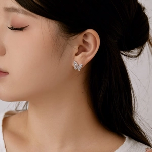 Close-up of S925 sterling silver butterfly earrings with cubic zirconia on a model