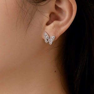Close-up of S925 sterling silver butterfly stud earrings with zircon inlay on a model