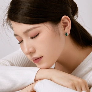 Gros plan de boucles d'oreilles S925 en argent avec zircon émeraude sur un mannequin