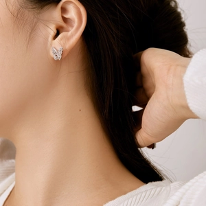 Close-up of S925 silver butterfly stud earring with zircon inlay on model ear