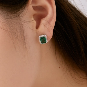 Gros plan de boucles d'oreilles en argent S925 avec zircons verts taille émeraude sur mannequin