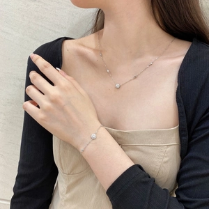 Detail of S925 silver halo necklace and bracelet set worn by model in a luxury style