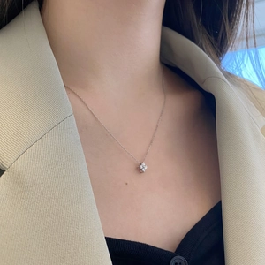 Gros plan du collier trèfle S925 en argent sterling avec oxydes de zirconium porté par modèle