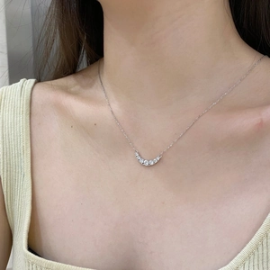 Close-up of S925 sterling silver smile necklace with five sparkling zircons on a model