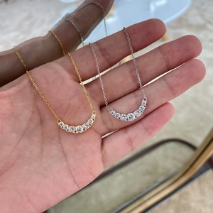 Detail of silver and gold U-shaped necklaces with sparkling curved row of 7 zircons