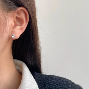 Close-up of elegant S925 sterling silver stud earring with sparkling zircon on ear