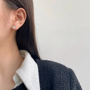Detail of S925 sterling silver stud earring with sparkling round zircon on a female model
