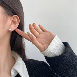Close-up of minimalist S925 silver stud earring with hand-set cubic zirconia on ear