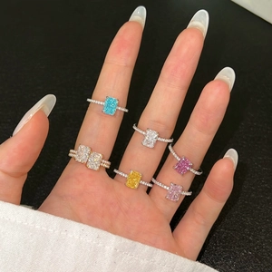Detail of colorful radiant cut gemstone rings in multiple colors on a female hand