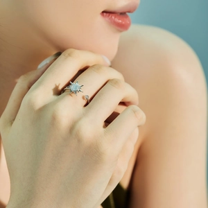 Detailaufnahme des drehbaren S925 Silberrings mit Sonnenmotiv und Mondstein am Finger