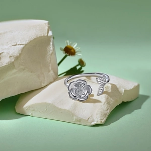 Detailaufnahme eines rotierenden S925 Sterlingsilber Rosenrings auf einem Marmordekorstein