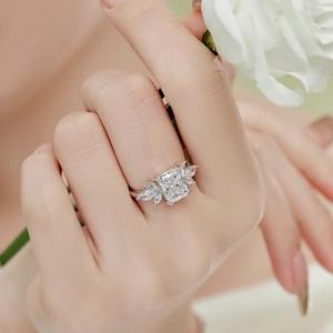 Gros plan d'une bague en argent S925 sertie de zircon et main tenant une rose blanche