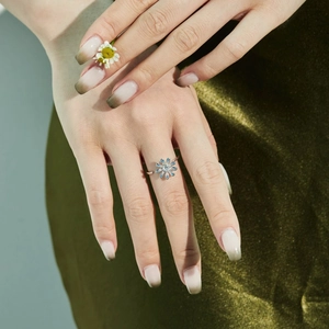 Makro-Detail des rotierenden Sonnenblumen-Rings mit blauen Kristallen und Zirkonia