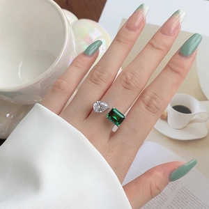 Close-up of S925 silver open ring with pear diamond and emerald cut gemstone on hand
