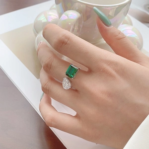 Close-up of Toi et Moi silver ring with emerald-cut green stone and pear-cut white zircon
